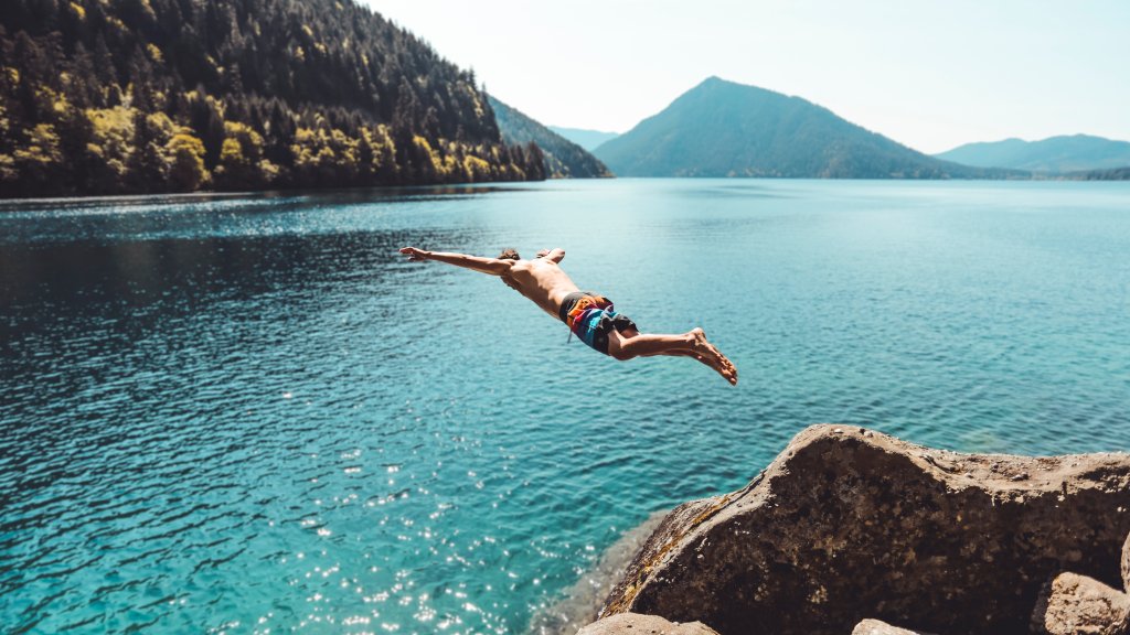 Young Man Jumping Into Alpine Lake - desktop wallpaper